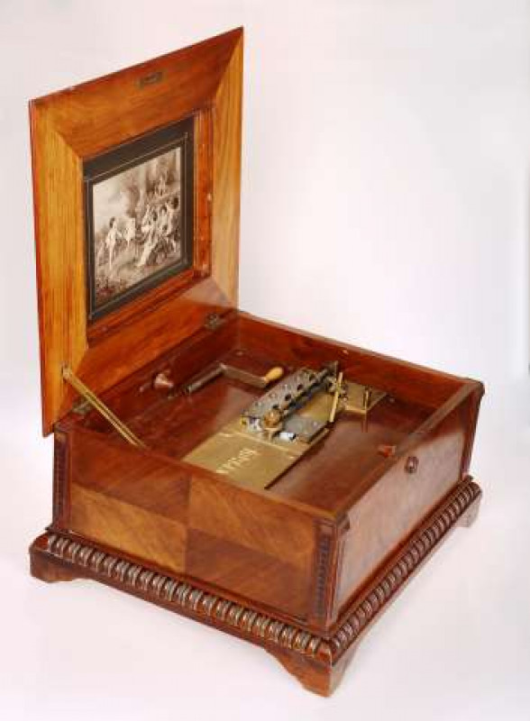 A WALNUT, ROSEWOOD AND FLORAL MARQUETRY TABLE TOP DISC PLAYER Signed Polyphon, circa 1890 The underside of the hinged cover with a print of musical putti, the double comb movement playing 39.5cm (15