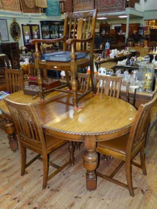 1920's carved oak extending dining table, two leaves and winder together with five dining chairs