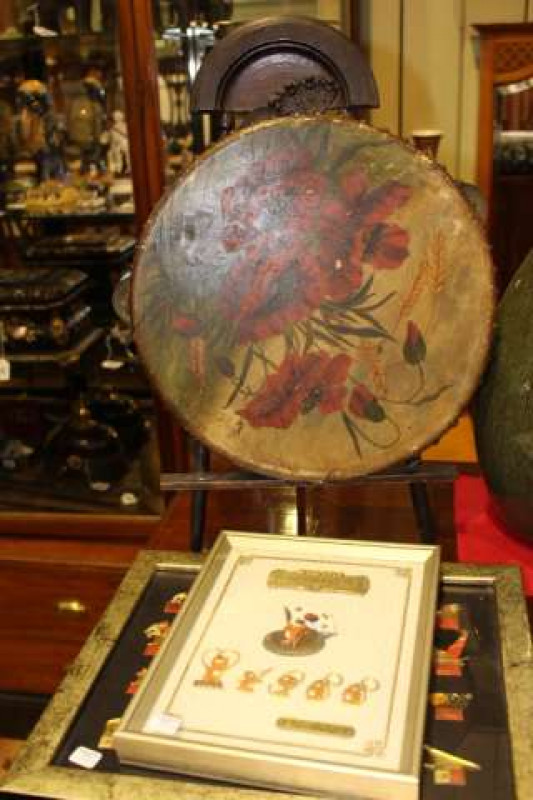 Painted tambourine on stand and two framed sets of Olympic badges