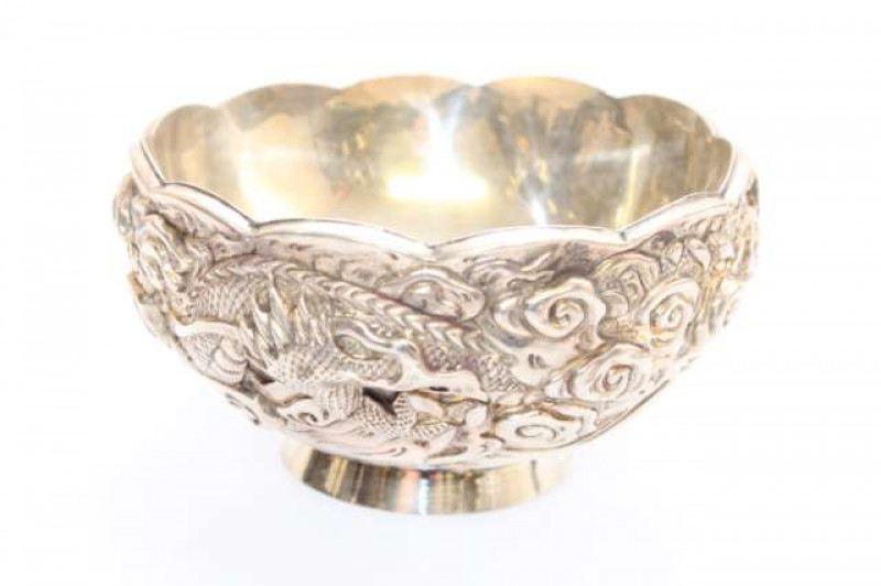 A NEAR PAIR OF JAPANESE SILVER BOWLS, bearing Junjin marks, Meiji period (1868-1912), of double walled construction with collet foot, boldly embossed with three-clawed dragons. Gross 14.9oz, diameter 13cm