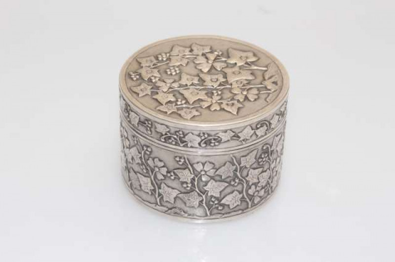 A CHINESE SILVER BOX AND COVER, mark of Wang Hing, late 19th/early 20th Century, cylindrical, embossed with plum blossom in low relief against a stippled ground, stamped '90' and 'WH'. 5.6oz, 6cm by 8.5cm