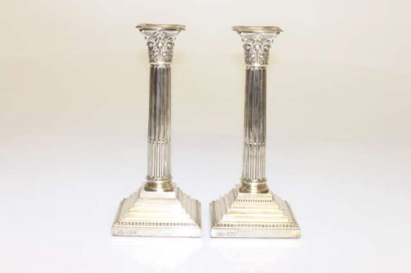 A PAIR OF EDWARDIAN SILVER CORINTHIAN COLUMN CANDLESTICKS, maker S.M. & S, Sheffield 1904, with detachable beaded drip pans and stepped square bases with beaded borders, weighted. 25cm