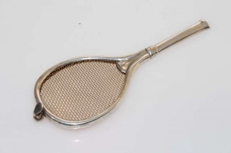 A GEORGE V NOVELTY SILVER LEMON STRAINER IN THE FORM OF A TENNIS RACKET, Chester 1911. 17.5cm