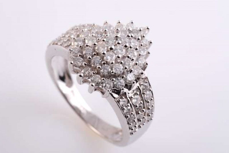 A DIAMOND RING, the pear shaped stepped mount set throughout with thirty six brilliant cut diamonds individually claw set diamonds, between heavy tapering shoulders each set with fourteen brilliant cut claw set diamond highlights in three rows, on a taper