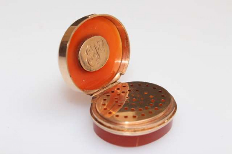 A SCOTTISH AGATE SNUFF BOX, c.1830, oval, the mounts unmarked but almost certainly gold, the lid with inset hair locket and monogrammed plaque to the underside, the interior with pierced grille. 3cm