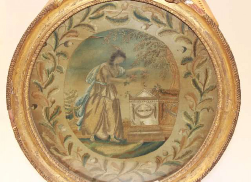 SHAKESPEARE INTEREST: A GEORGE III SILKWORK PICTURE, slightly oval, of Fame adorning a tomb inscribed 'SHAKESPEAR', in a gilt gesso frame. Overall 50.5cm
