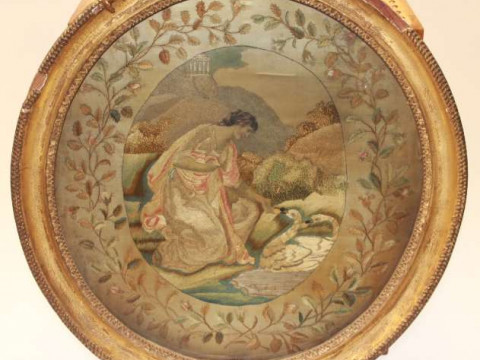 A GEORGE III SILKWORK PICTURE, slightly oval, of a lady feeding two swans...