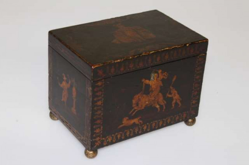 AN 18TH CENTURY BLACK JAPANNED CHINOISERIE TEA CADDY, of rectangular form, decorated with figures, raised on cast brass ball feet. 15cm by 19.5cm by 13cm