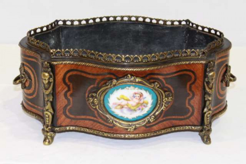 A LOUIS XV STYLE GILT-METAL MOUNTED AND KINGWOOD JARDINIERE, of serpentine outline with pierced gallery, applied with a cast-mask mount, porcelain panel and twin handles. 41cm by 27cm