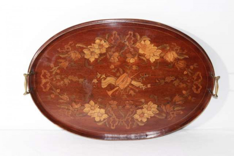 AN EDWARDIAN INLAID MAHOGANY OVAL TRAY, galleried, inlaid with a musical trophy and ribbon-tied foliage, with brass handles. 66.5cm by 44cm