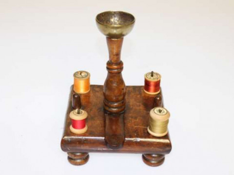 A WALNUT SEWING STAND, 18th Century, the square platform with four bobbin...