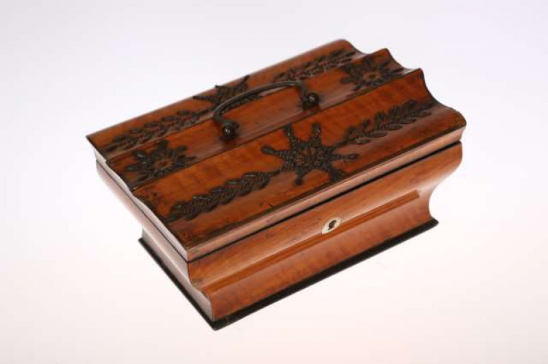 A GEORGE III SATINWOOD AND CUT-STEEL SEWING BOX, c.1790, of waisted rectangular form, the hinged moulded lid applied with cut-steel to form a formal pattern of flowerheads and leaves, the underside fitted with a mirror, the interior with a lift-out tray p
