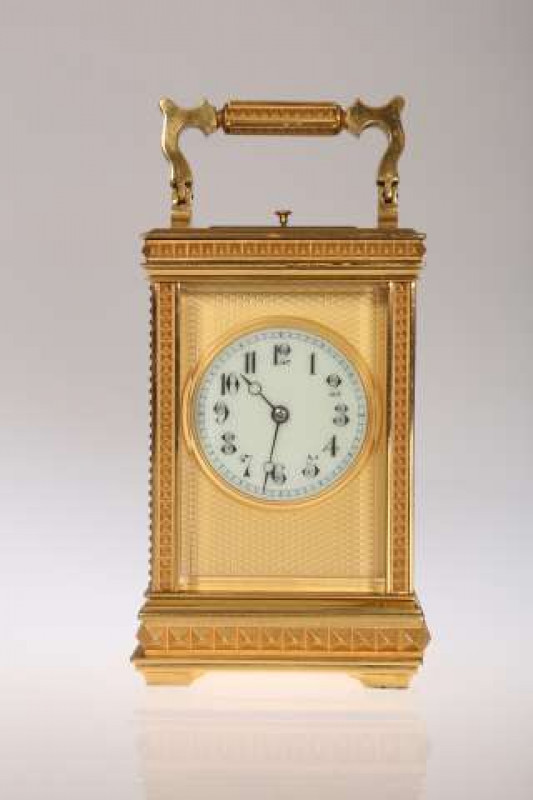 A 19TH CENTURY BRASS CASED STRIKING AND REPEATING CARRIAGE CLOCK, the cornice case enclosing a circular enamel dial with Arabic numerals, with key. 15cm high excluding handle