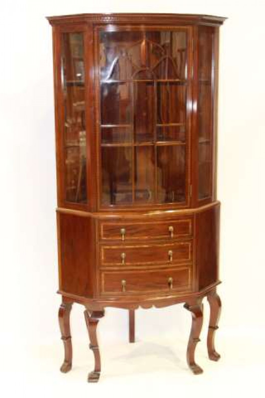 AN EDWARDIAN INLAID MAHOGANY CORNER CABINET, with a projecting moulded cornice above Greek Key moulding with an astragal glazed door below, the base with three graduated drawers, raised on square-section cabriole legs terminating in blocks. 185cm by 94cm 