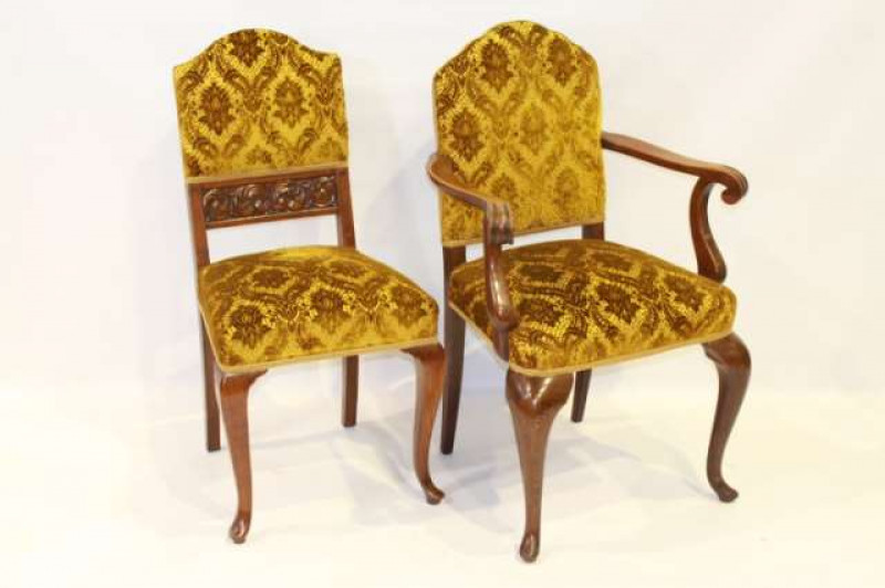 A SET OF NINE LATE 19TH CENTURY OAK DINING CHAIRS, including one carver, each with upholstered arched back panel and stuffed over seat, raised on cabriole legs terminating in pads.