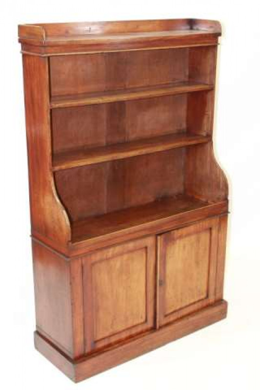 A REGENCY MAHOGANY WATERFALL BOOKCASE, with open shelves above a pair of panel doors, raised on a plinth base. 145.5cm by 92cm by 38cm