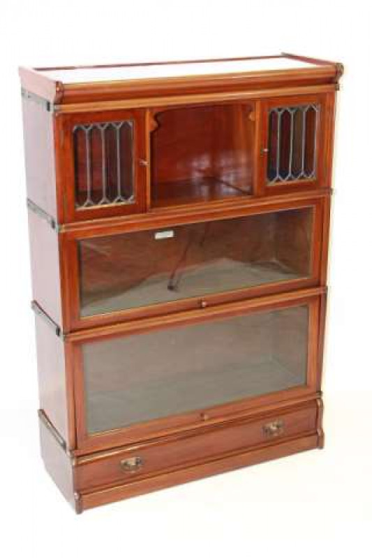 A GLOBE-WERNICKE MAHOGANY BOOKCASE, c.1900, the upper section with a recess flanked by a pair of lead-glazed doors over two glazed sections above a base drawer, labelled. 125cm by 86.5cm by 30.5cm