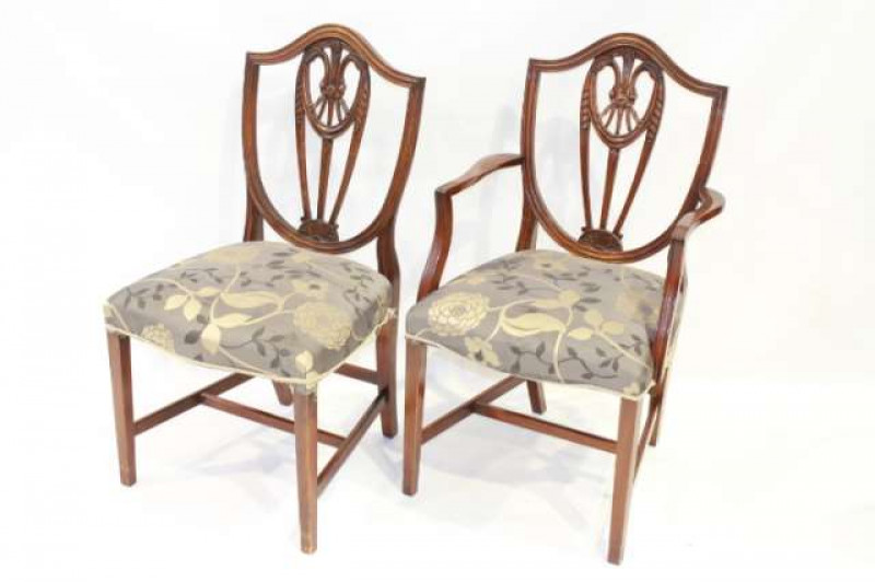 A SET OF EIGHT HEPPLEWHITE STYLE MAHOGANY SHIELD-BACK DINING CHAIRS, including a pair of carvers, with stuffed over seats and slightly bowed rails, raised on square-section tapering legs.