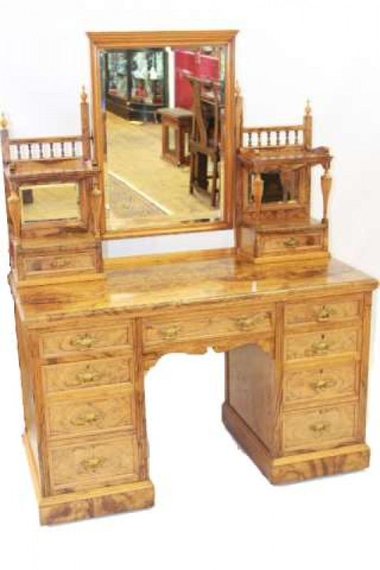 A MAPLE & CO OLIVE WOOD DRESSING TABLE, 19TH CENTURY, with mirrored superstructure fitted with two pairs of drawers, the moulded top above a frieze drawer over a kneehole flanked by two banks of four graduated drawers, raised on a plinth base and moving o