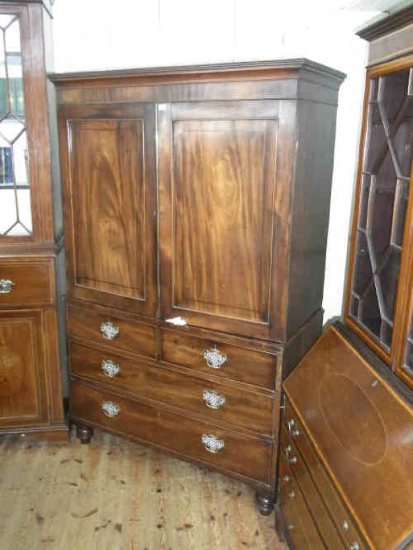 XIXth Century Mahogany Linen Press, having double doors above drawers on turned legs