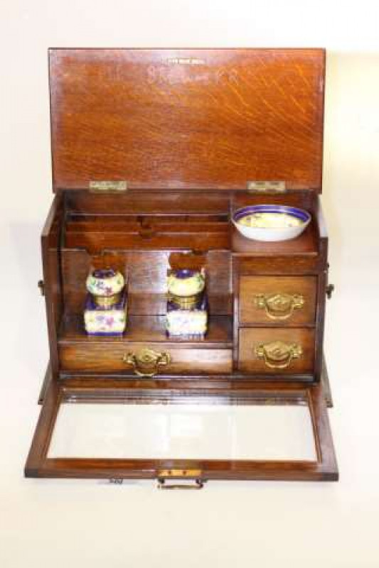 Late Victorian oak drop glazed front writing box, fitted and with china inkwells