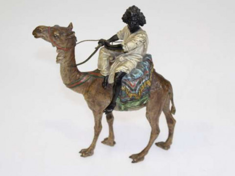 Cold painted bronze of a Nubian riding a camel, possibly by Bergman, stamped...