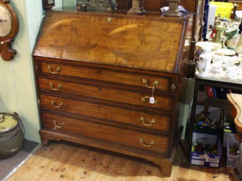 George III mahogany four drawer bureau on shell inlaid bracket feet