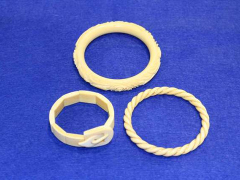 Three ivory bangles including one gold weaved
