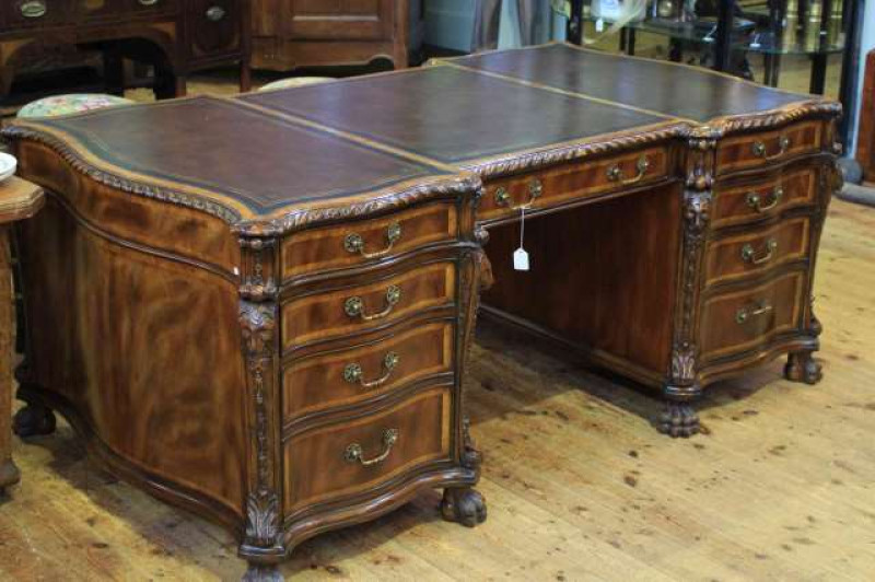 Highly impressive good quality mahogany partners desk with gilt tooled leather inset top, gadroon border, serpentine shaped pedestals with lion mask quarters and paw feet and having nine drawers to front and reverse, 186cm long x 105cm wide x 77cm high