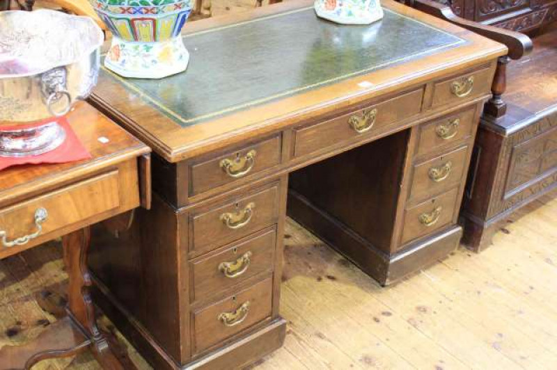 Early 20th Century oak nine drawer pedestal with gilt tooled green leather inset top