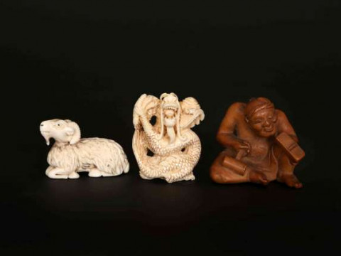 A JAPANESE WOODEN NETSUKE, carved as a carpenter eyeing his plane, 4cm...
