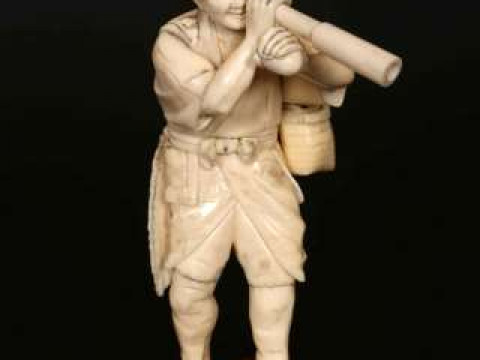 A JAPANESE IVORY OKIMONO, Meiji period (1868-1912), carved as a man looking...