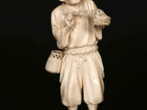 A JAPANESE IVORY OKIMONO, Meiji period (1868-1912), carved as a man feeding...