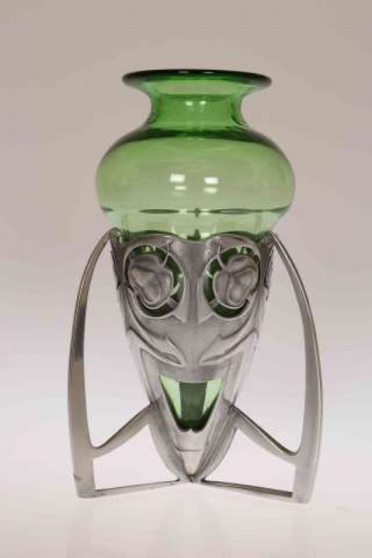 ARCHIBALD KNOX FOR LIBERTY & CO, AN ENGLISH PEWTER AND GREEN GLASS BOMB VASE, cast and pierced in low relief with stylised foliage, enclosing a bulbous green glass liner, no. 0226, stamped ENGLISH PEWTER. 19cm