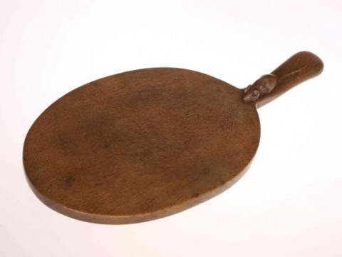 ROBERT THOMPSON OF KILBURN, A MOUSEMAN OAK CHEESEBOARD, oval with carved...