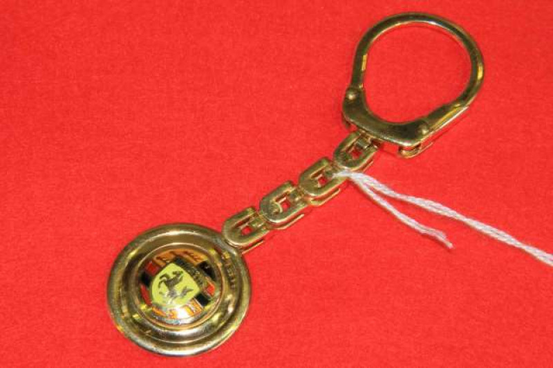 An Italian yellow metal and enamel Porsche key fob, Firenze, stamped 750 and indistinctly signed, 31 grams
