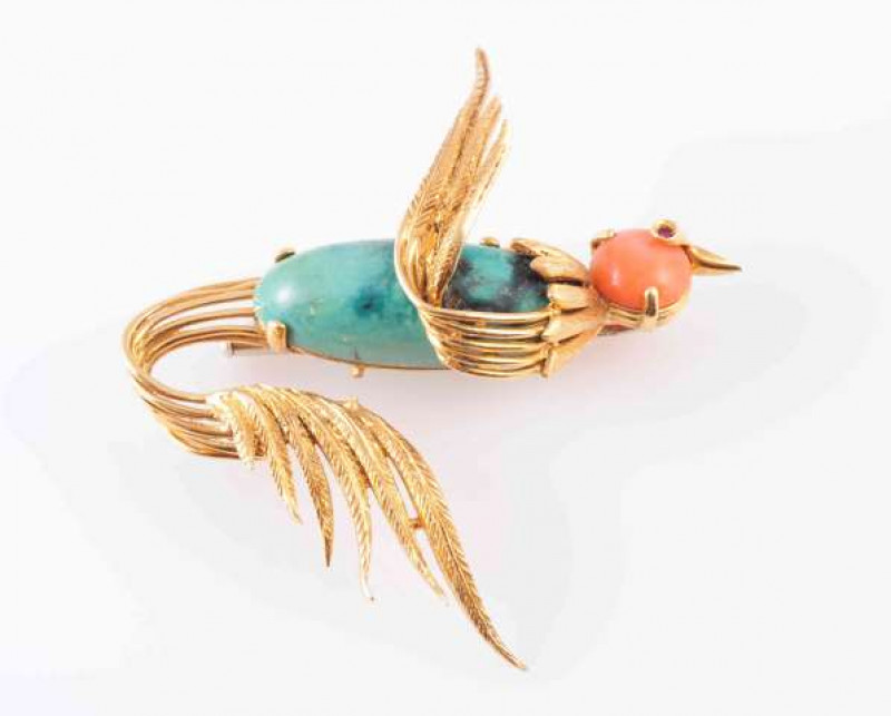 A CORAL, TURQUOISE AND GOLD BROOCH, modelled as a bird in flight, the oval shaped turquoise bead as the body, four claw set in an open mount with banded textured metal work depicting the tail and wings, set to the top with a circular cut claw set coral be