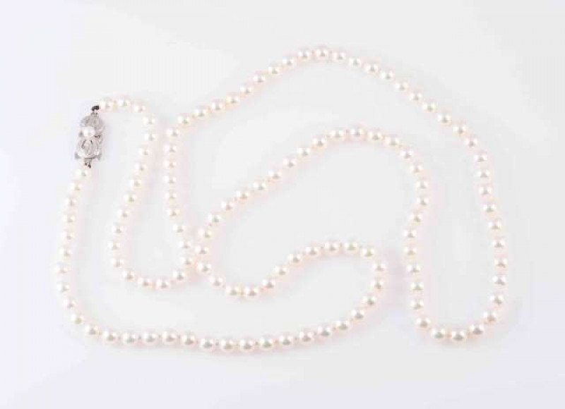 A CULTURED PEARL NECKLACE BY MIKIMOTO, the one hundred and twenty three uniform cultured pearls strung knotted onto a pierced bow design integral tongue clasp set to the centre with a single cultured pearl. Clasp stamped 750, with makers mark M. Total len