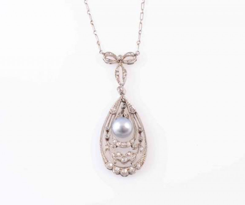 A DIAMOND AND PEARL NECKLACE, CIRCA 1910, the single pearl suspending on an articulated link to the bottom of a leaf shaped mount set throughout with three diamond highlights, within a delicate pierced work surround of scalloped edges and leaf shaped moun