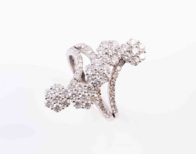 A DIAMOND DRESS RING, the five flower heads each set with seven brilliant-cut diamonds, above diamonds set split shoulders, set in total with thirty two brilliant-cut diamonds, above plain hoop. Ring size P 1/2. Total weight approximately 7 gms.