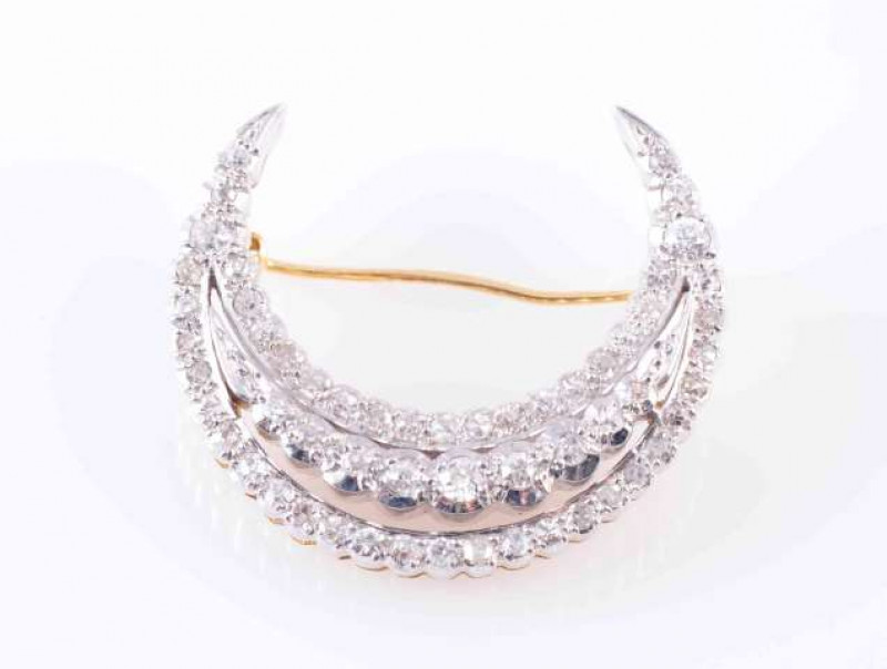 A DIAMOND SET CRESCENT BROOCH, composed of three crescent shaped mounts, the central mount slightly raised and set with a graduating row of nine circular-cut diamonds in rub over collet setting, the outer rows set with twenty four and seventeen circular-c