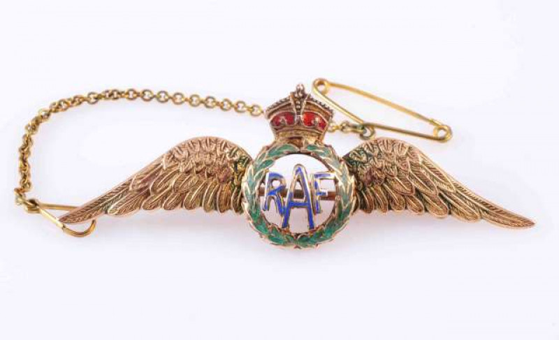 A GOLD AND ENAMEL RAF BROOCH,  the central motif decorated with blue, green and red enamel, between textured gold wings. Stamped 9ct. 5.5cm long. Total weight approximately 4.4gms. Enamel worn.