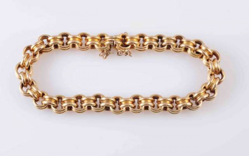 A GOLD BRACELET, the heavy curb links with moulded detailing to the centre, each articulated on an integral tongue clasp. Total length approximately 18cm. Weight 30.8gms.