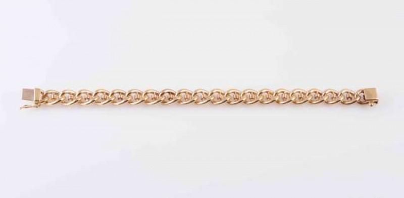 A GOLD COLOURED BRACELET, the interlinked moulded circular links joined by an integral tongue clasp with safety chain. Length approximately 18.5cm. Weight 17.3gms.