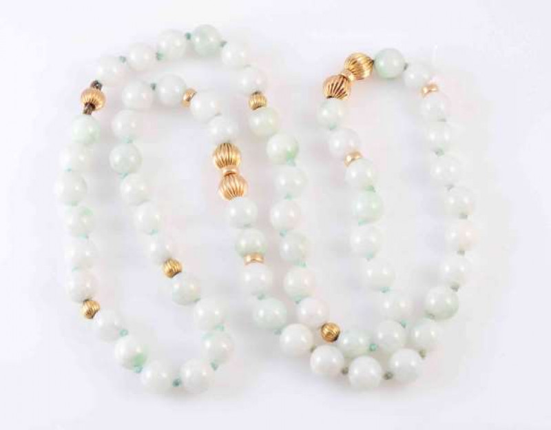 A GREEN BEAD AND GOLD BEAD NECKLACE, the sixty one uniform green beads string knotted amongst alternately spaced yellow gold colour moulded detail bead spacers. Length approximately 34cm. Weight 83gms.