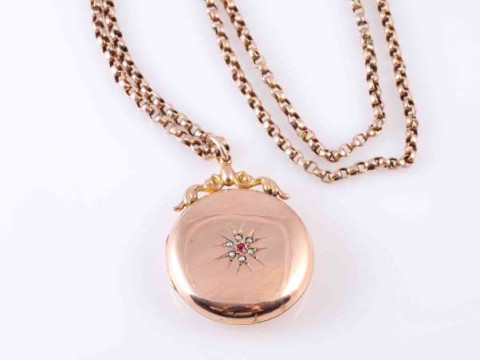 A LATE VICTORIAN GOLD LOCKET, the circular locket inset to the front with...