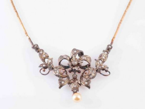A PORTUGESE DIAMOND, SILVER AND GOLD PENDANT, the central floral cluster...