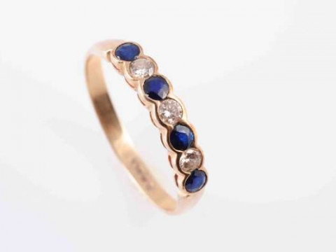A SAPPHIRE AND DIAMOND RING, the four round cut sapphires alternately...