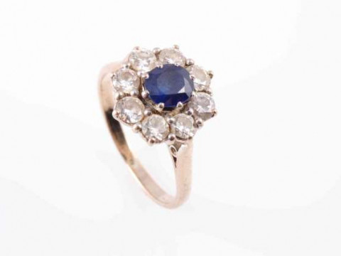 A SAPPHIRE AND DIAMOND RING, the round cut sapphire eight claw set within...