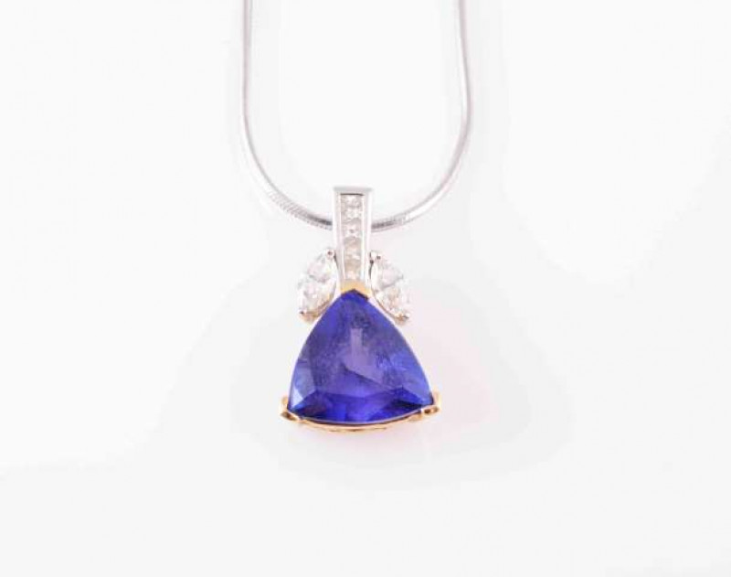 A TANZANITE AND DIAMOND NECKLACE, the trillion-cut tanzanite with three chevron style claws below a diamond surmount set with two marquise-cut diamonds either side of four slightly graduating and channel set princess-cut diamonds. Mount stamped '18K', on 